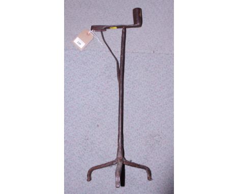 A wrought iron rush light holder/candlestick, on tripod base, 23" high