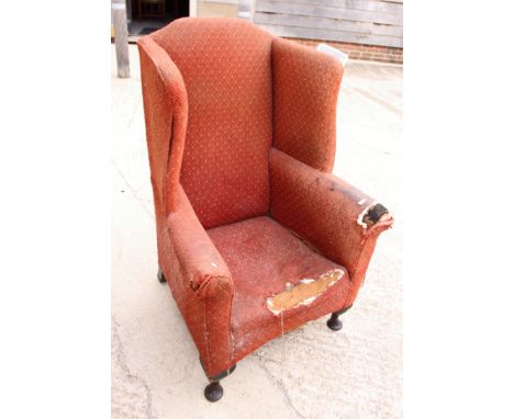 A stained as mahogany three-shelf waterfall bookcase, on bracket supports, 36" wide, and a late Georgian high wing armchair (