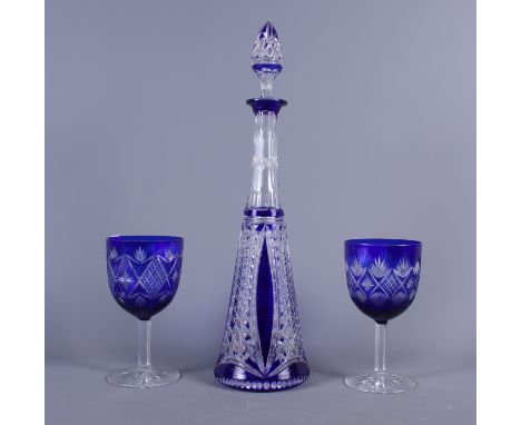 A blue flashed conical decanter with stopper and two similar wine glasses