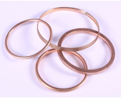 Three 9ct gold bangles, 42.9g, and a similar 9ct gold metal core bangle