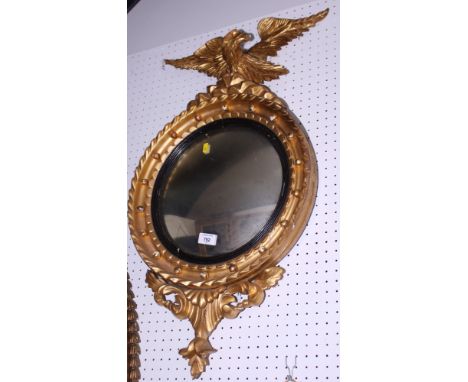 A Regency style giltwood framed convex wall mirror with eagle surmount, 31" high (damages)