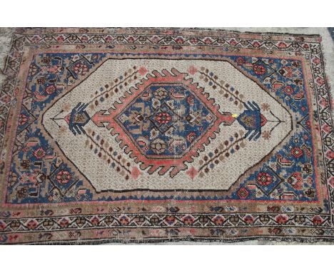 A tribal rug with central medallion on a light ground, 70" x 44" approx, and one other rug 63" x 38" approx (worn)