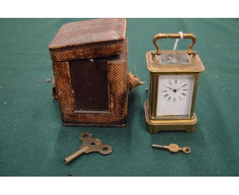 A miniature brass carriage clock with leather travelling case.