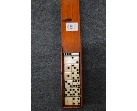 Mahogany box containing ebony and bone dominoes.