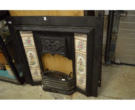 Cast iron fireplace with tile inset panels together with a grate and fender.