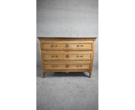 A late 19th century French oak three drawer commode raised on facetted tapering supports. H.94 W.122 D.52 