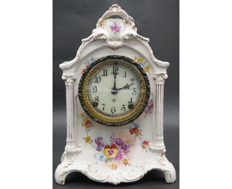 An Ansonia porcelain mantel clock with enamel dial and black Roman numerals, decorated with floral design and with gilded rim