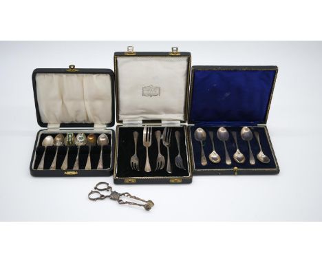 Three cased sets of silver cutlery and a pair of Georgian silver sugar nips. A cased set of six silver coffee spoons hallmark