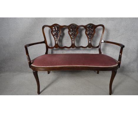 A late 19th century mahogany salon sofa with carved and pierced triple chair back on slender cabriole supports. H.91 W.214 D.