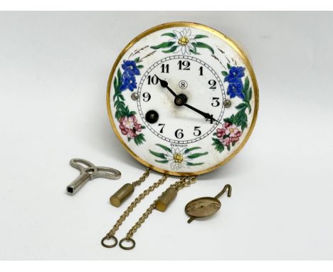 A Mid 20th Century miniature German enamel face wall clock. With original box, key and pendulum. 7cm