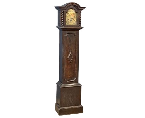 An early 20th century oak long case clock with brass face by Tempus Fugit, in the Jacobean style. With key and pendulum.