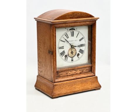 Beringer Bros, Belfast. A Late 19th Century inlaid oak cased mantle clock. By Beringer Bros. With key and pendulum. 21.5x14x3
