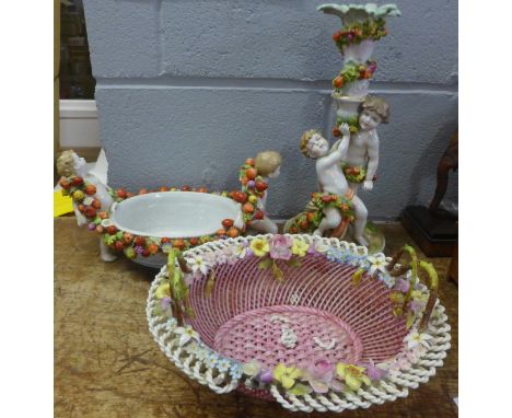 A Von Schierholz centrepiece and a candlestick decorated with cherubs and fruit, and a basket, basket a/f 
