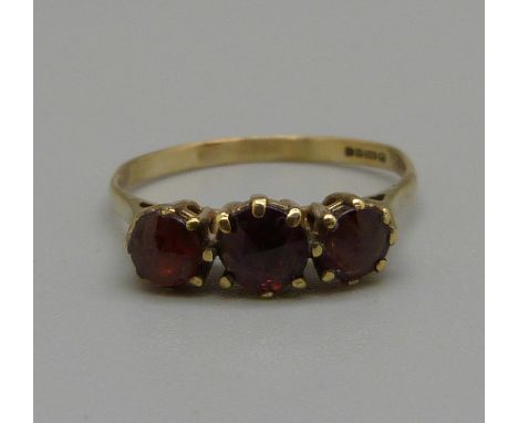 A 9ct gold, three stone garnet ring, 1.6g, L 