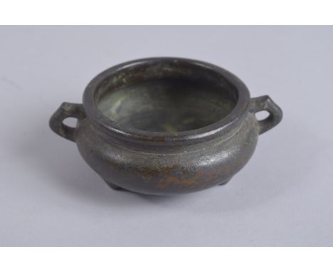 A CHINESE BRONZE TWIN HANDLE CENSER, with character mark to base, 12.5cm wide handle to handle.
