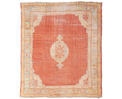 USHAK CARPET WEST ANATOLIA, LATE 19TH/EARLY 20TH CENTURY the plain red field with blue and red medallion, within light blue p