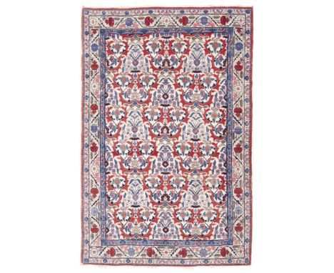 TEHRAN RUG CENTRAL PERSIA, EARLY 20TH CENTURY the cream field with allover red floral and foliate lattice pattern, within lig