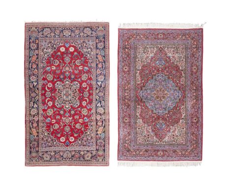 TWO KASHAN RUGS CENTRAL PERSIA, 20TH CENTURY one with red field with indigo floral medallion, similar spandrels, within flora