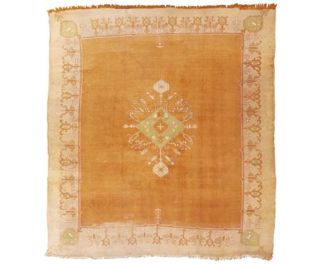 USHAK CARPET WEST ANATOLIA, LATE 19TH/EARLY 20TH CENTURY the plain orange field with green lozenge medallion, within light or