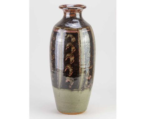 † EDDIE HOPKINS (1941-2007) for Winchcombe Pottery; a tall stoneware bottle partially covered in tenmoku breaking to kaki gla