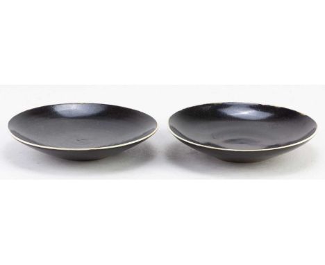 † LUCIE RIE (1902-1995) &amp; HANS COPER (1920-1981); a pair of stoneware side plates covered in black glaze, impressed LR an