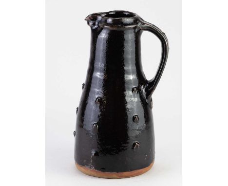 JIM MALONE (born 1946); a tall stoneware pitcher covered in tenmoku breaking to kaki glaze with impressed decoration, impress