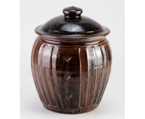 † MIKE DODD (born 1943); a fluted stoneware jar and cover covered in tenmoku breaking to kaki glaze, impressed MJD mark, heig