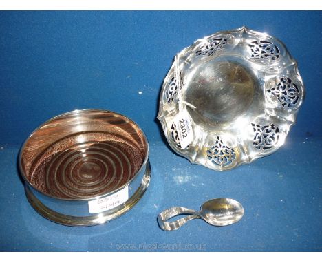 A small pierced white metal bonbon Dish, plus an early 20th c. caddy Spoon and a plate on copper mahogany base bottle Coaster