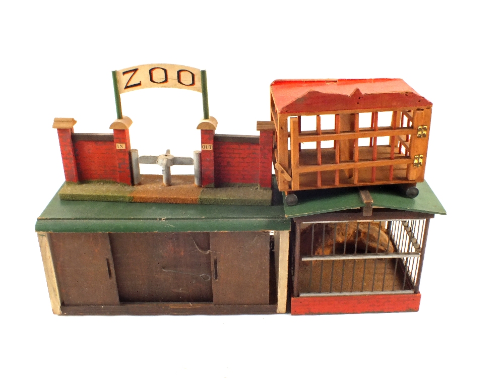 A wooden toy zoo including cages and lead animals