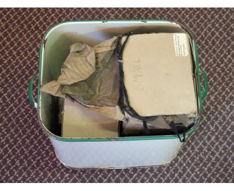 An enamel bin containing four gas masks