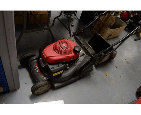 A Honda HRX 426C pedestrian-controlled lawnmower, in red, with operator's manual. 