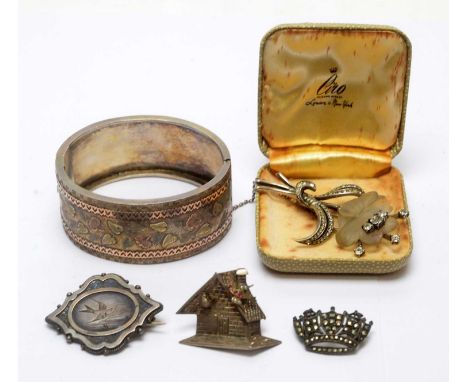 A silver bangle, with yellow, rose and silver leaf design; a glass and paste stone set flower brooch; and three silver brooch