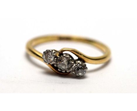 A three stone diamond ring, in crossover mount on an 18ct gold shank, ring size P, 2.4g gross. 