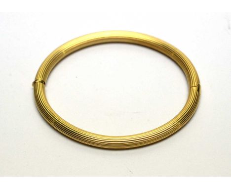 An 18ct yellow gold bangle, with fluted design, hollow cast, 11.9g gross. 