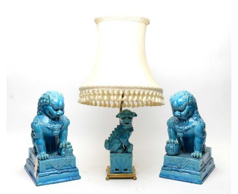 A pair of Chinese Buddhist lion figures, blue glazed, raised on a stepped rectangular base, 35cms high; together with a simil