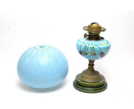 A Victorian brass oil lamp, the blue glass reservoir painted with floral designs, raised on a green ceramic base; together wi