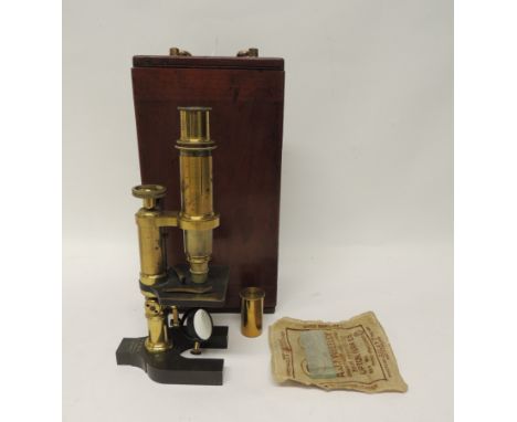 A brass monocular microscope by Baker, 244 High Holborn, London, the horseshoe base engraved with makers name and with single