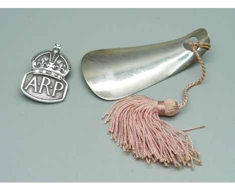 A silver ARP badge and a silver child's shoe horn 