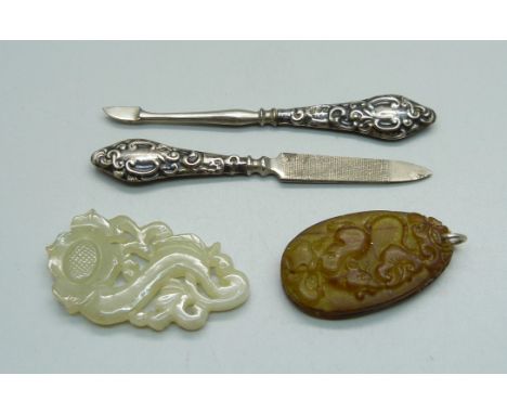 A carved jade pendant, one other pendant and two silver mounted manicure tools 