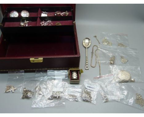 A collection of silver jewellery including a garnet and opal cluster ring, a silver thimble and a silver spoon in a jewellery