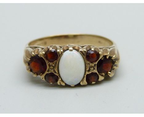 A 9ct gold ring set with an opal and six garnets, 3.4g, R, (very small chip to the opal) 