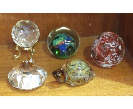 A Swarovski glass faceted paperweight on stand and four other modern glass paperweights, (5). 
