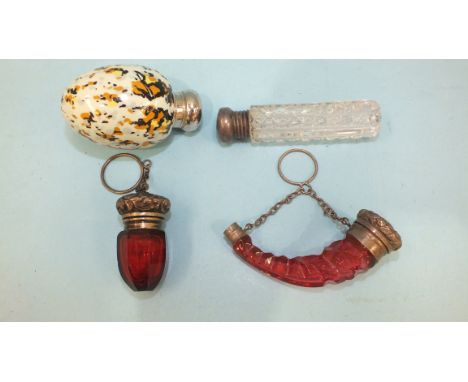 Two silver-mounted cranberry glass scent bottles, a clear glass scent vial and an egg-shaped ceramic bottle with metal cap, (