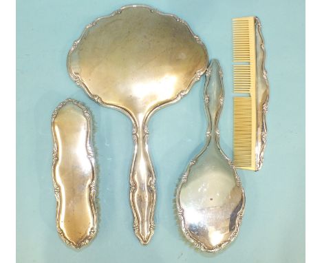 A Continental silver-backed hand mirror, clothes brush, hair brush and comb, marked .835, (4). 