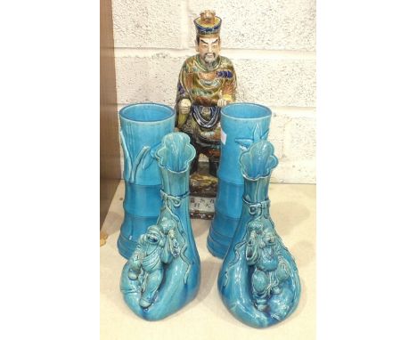 A 20th century Japanese ceramic figure of a deity holding a scroll, with a dog's head protruding from his headwear, 39cm high