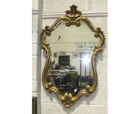 A modern gilt scrolling frame wall mirror, 98 x 63cm, a wool-work picture and an oleograph picture, (3). 