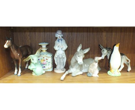 A Lladro figure of a clown playing a saxophone, 22cm high, a Lladro figure of a donkey lying down, 28cm long, 16cm high, a Br