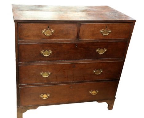 A George III oak chest of two above three drawers with brass swing handles, standing on bracket feet.