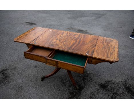  A George IV rosewood sofa table, drop leaves above twin frieze drawers, on turned pillar support above four acanthus carved 