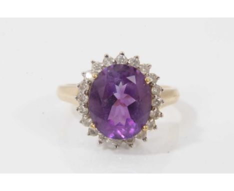 9ct gold amethyst and diamond cluster ring with an oval mixed cut amethyst surrounded by a border of twenty brilliant cut dia